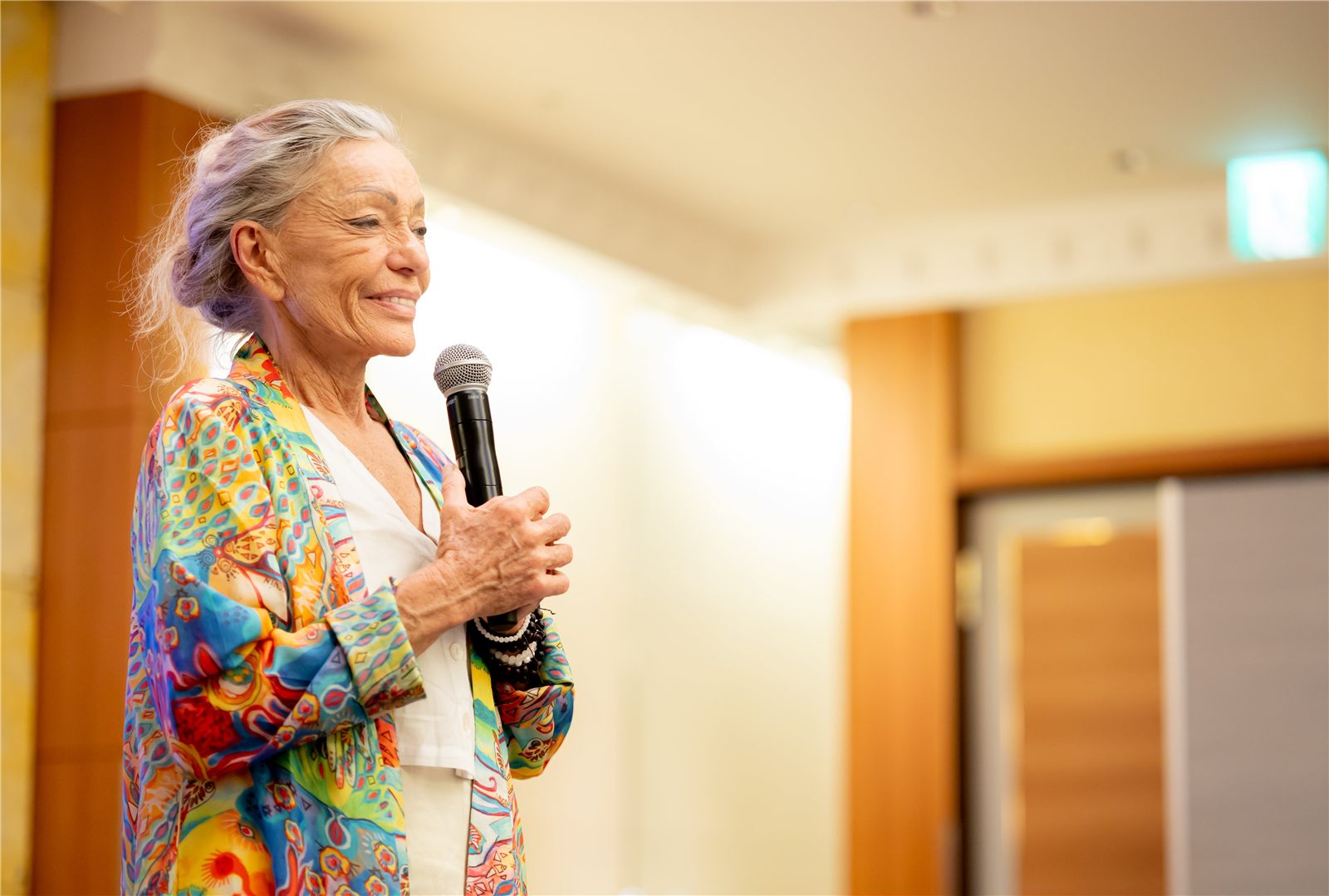 マイクを持って講演するネリー博士